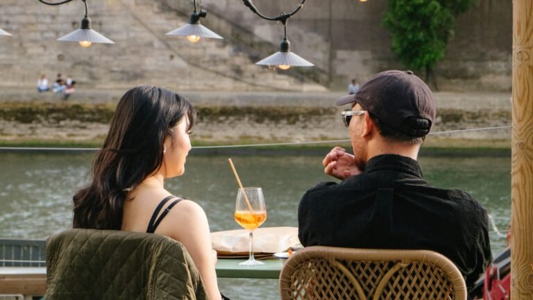 Couple prenant un verre en terrasse au bord de l'eau