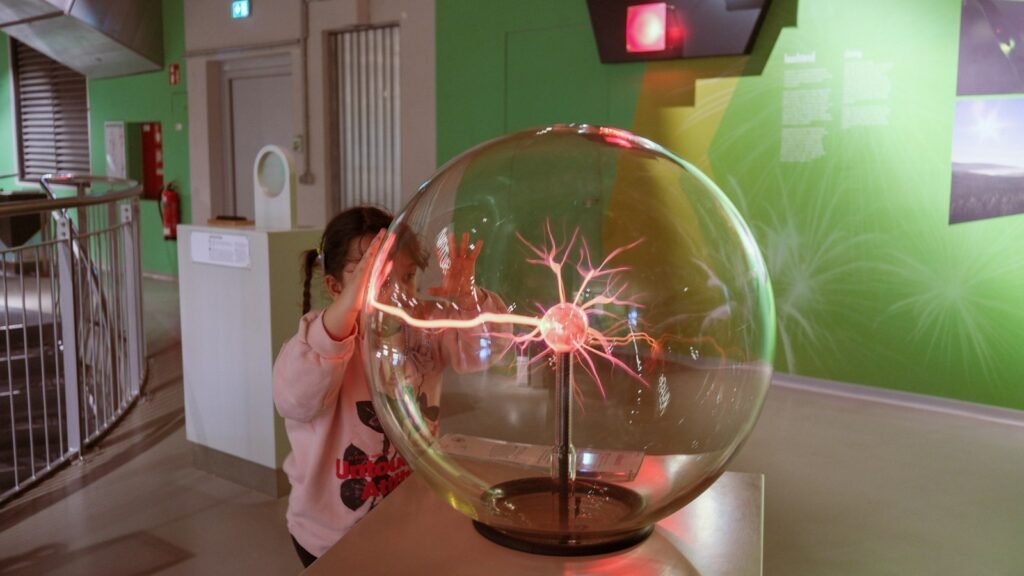 Enfant touchant une boule plasma dans une exposition scientifique